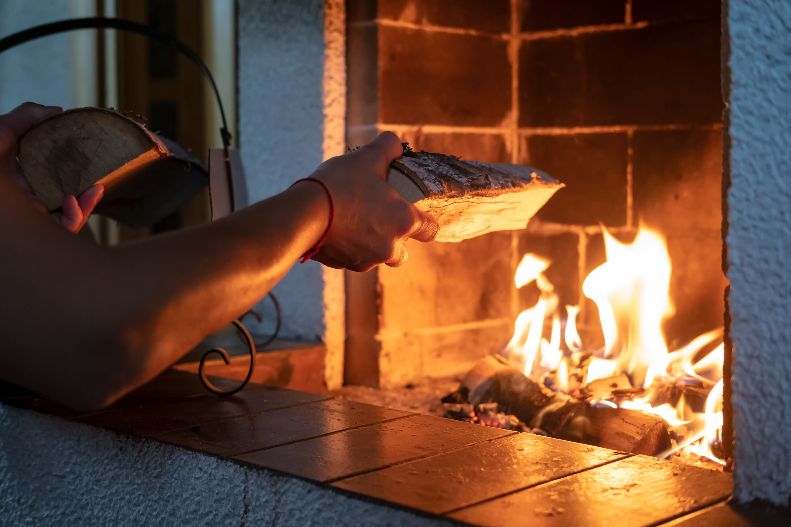 A homeowner adds another log to the fire.
